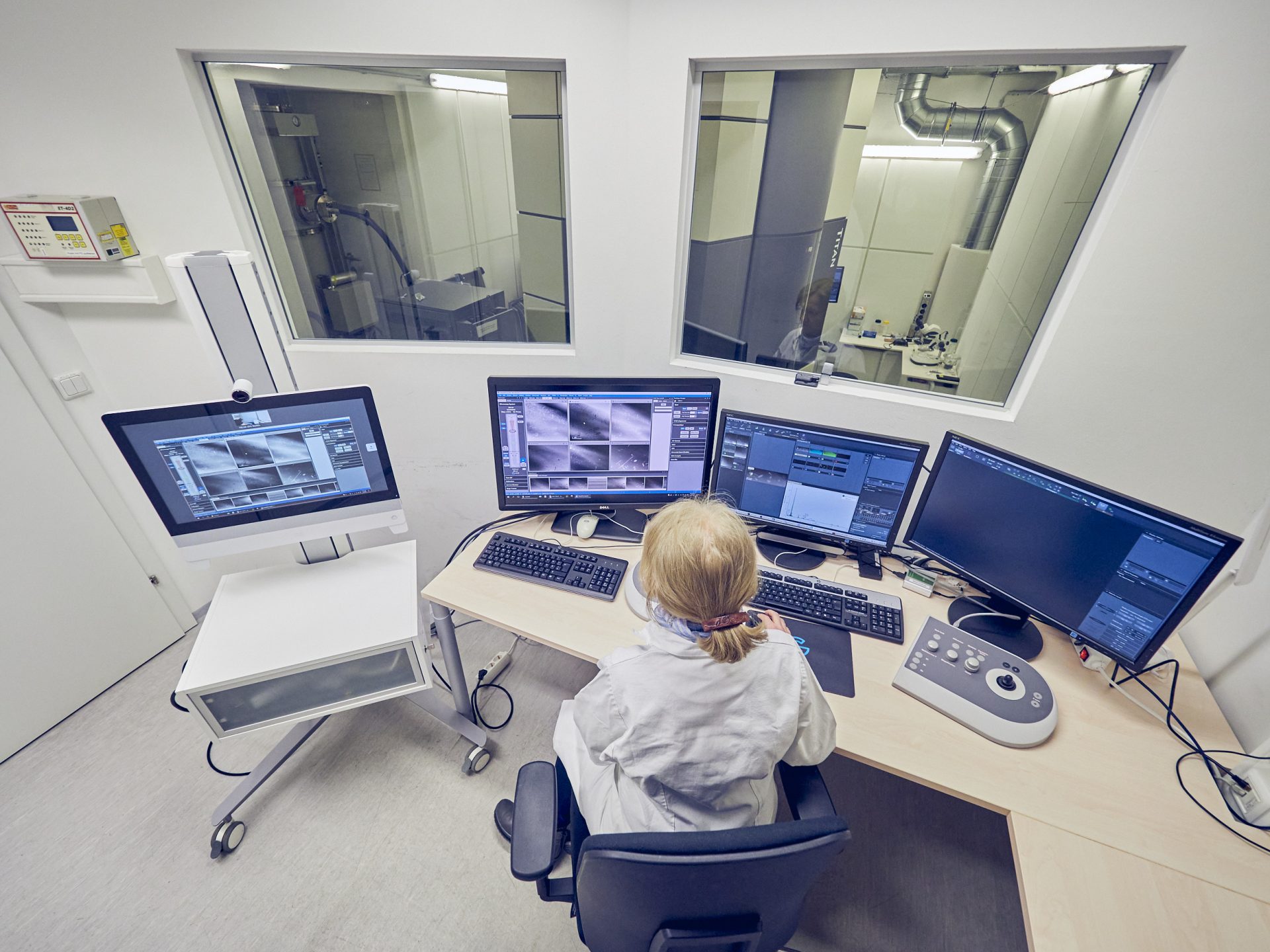 Frau vor vier Bildschirmen