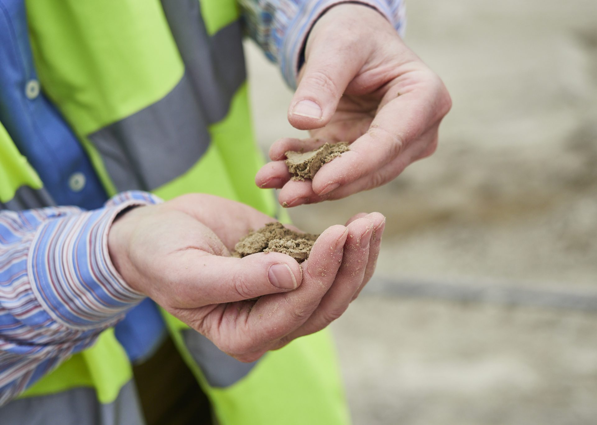 Hände in Großaufnahme untersuchen Lehm
