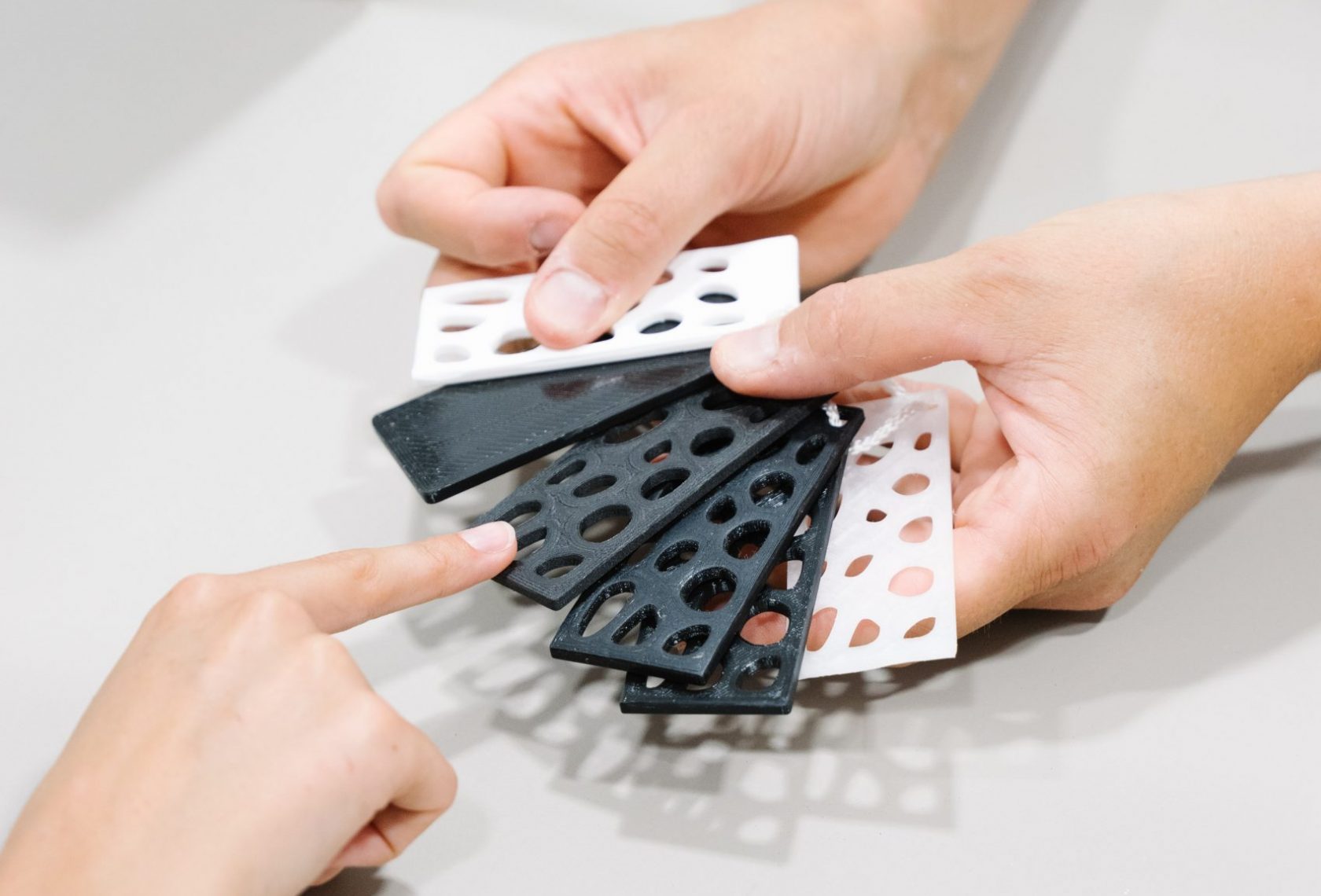 Symbolfoto, Person zeigt verschiedene Kunststoffteile