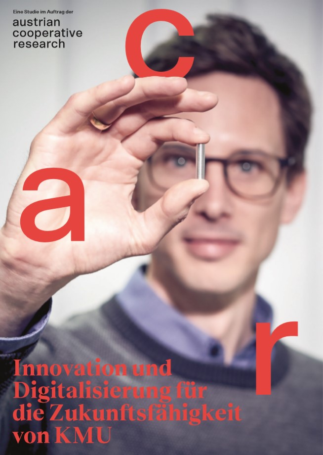 Coverbild zeigt Forscher in Nahaufnahme, der ein Metallstück hochhält