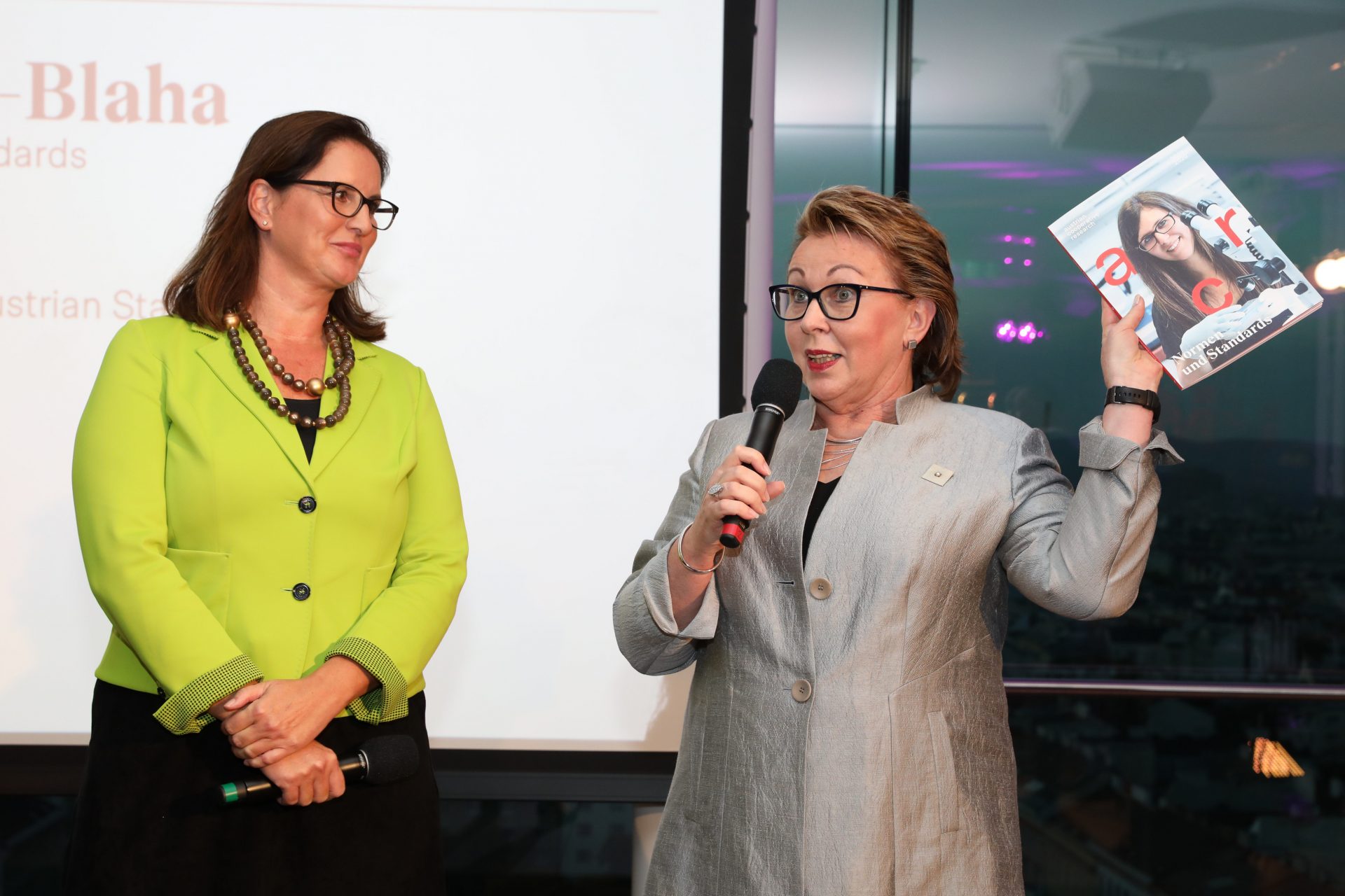 Valerie Höllinger und Elisabeth Stampfl-Blaha auf der Bühne, in der Hand den ACR Jahresbericht 2019