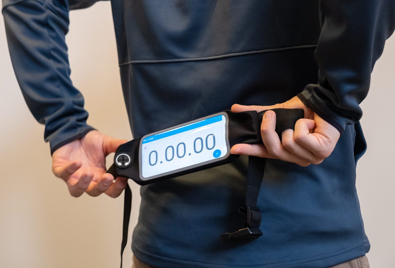 Mann schnallt sich einen Hüftgurt mit Display um die Hüften.
