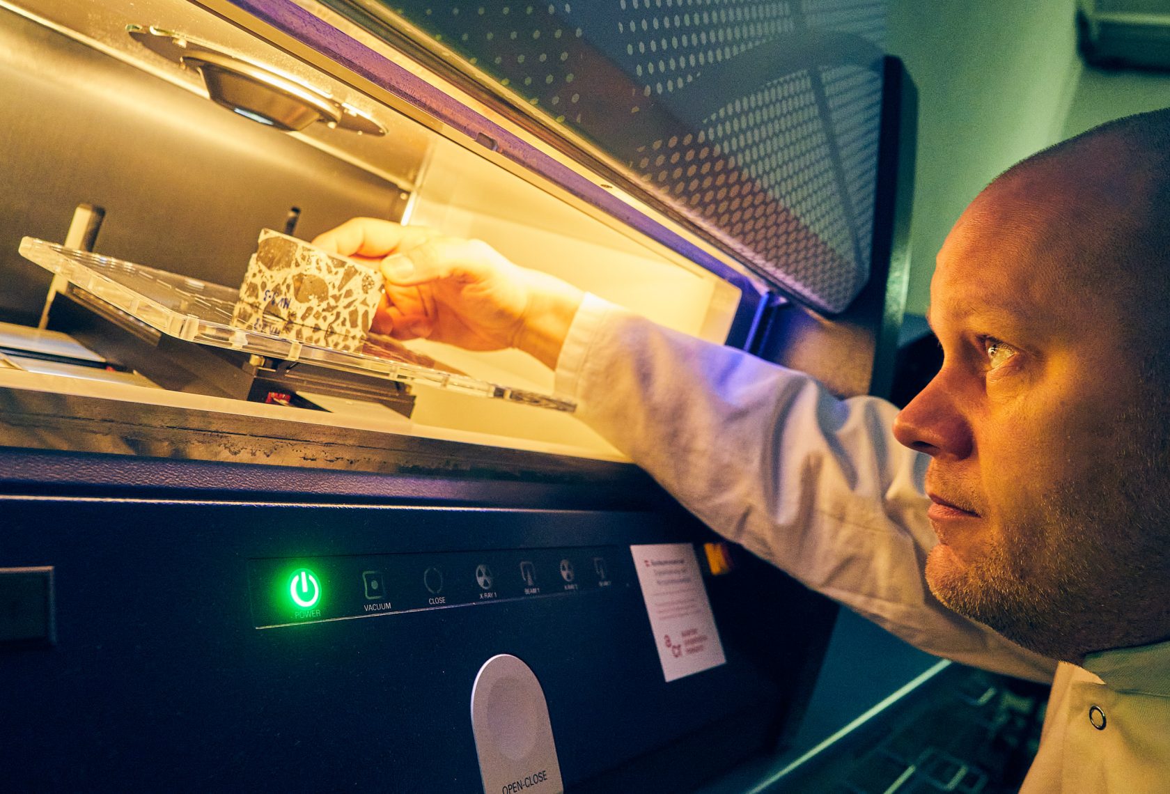 Foto: ACR/schewig-fotodesign Forscher positioniert eine Betonprobe in einem Testgerät