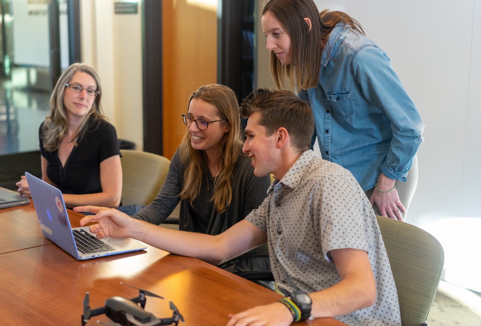 Foto: clayton-cardinalli-unsplash Teamkolleg*innen schauen auf einen Computerbildschirm und lachen