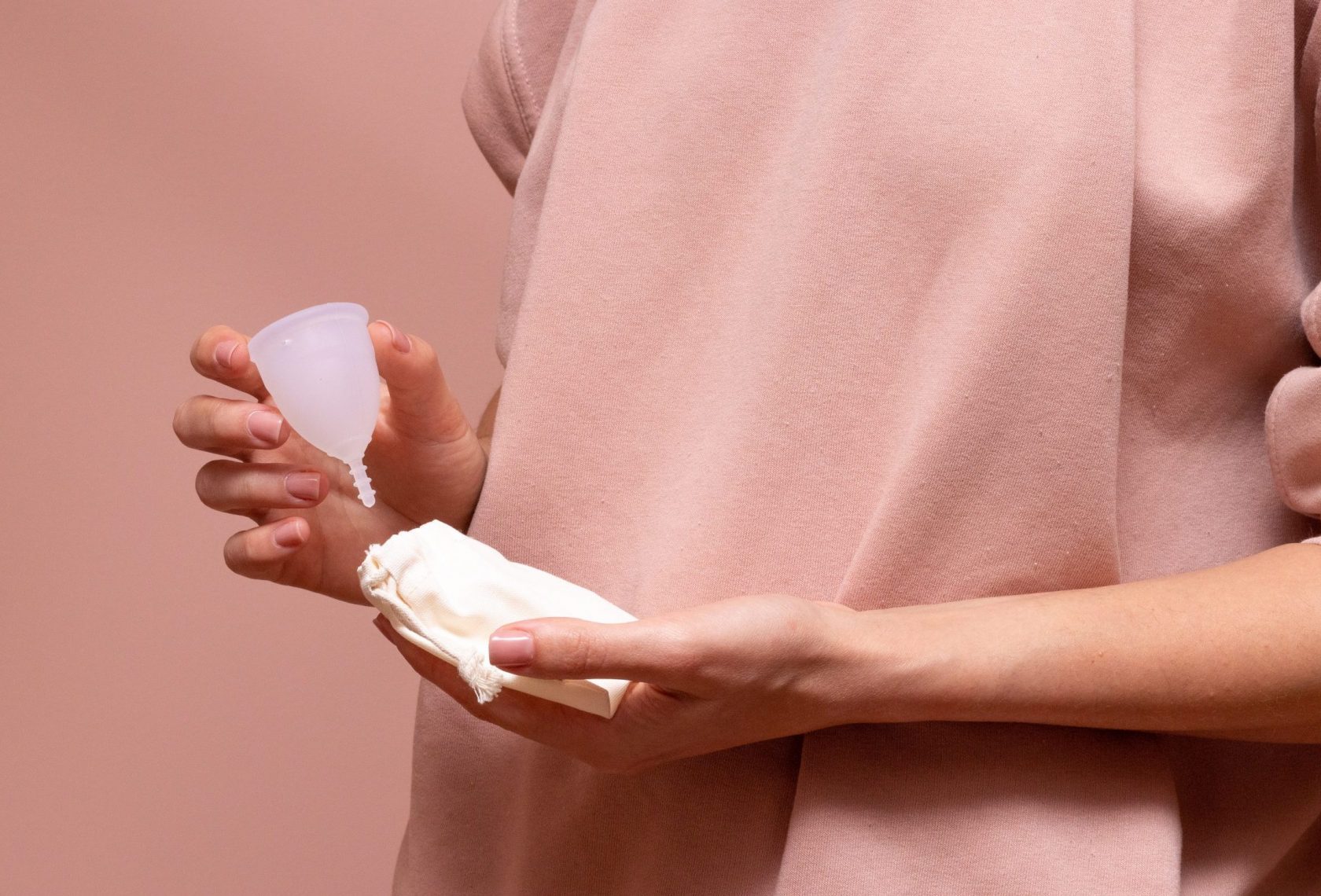 Frau hält Menstruationscup in der Hand