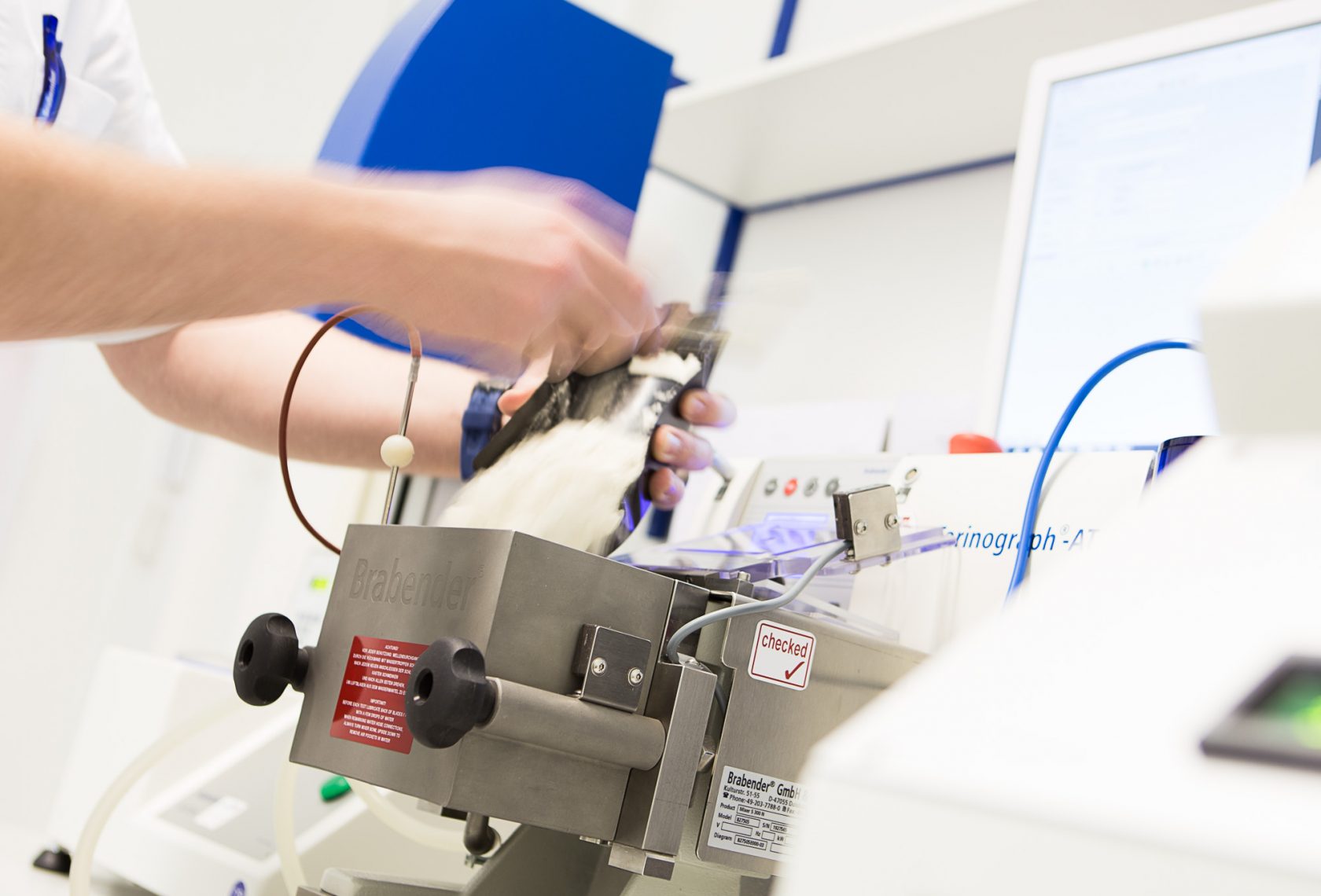 Hände prüfen den Teig in der Maschine