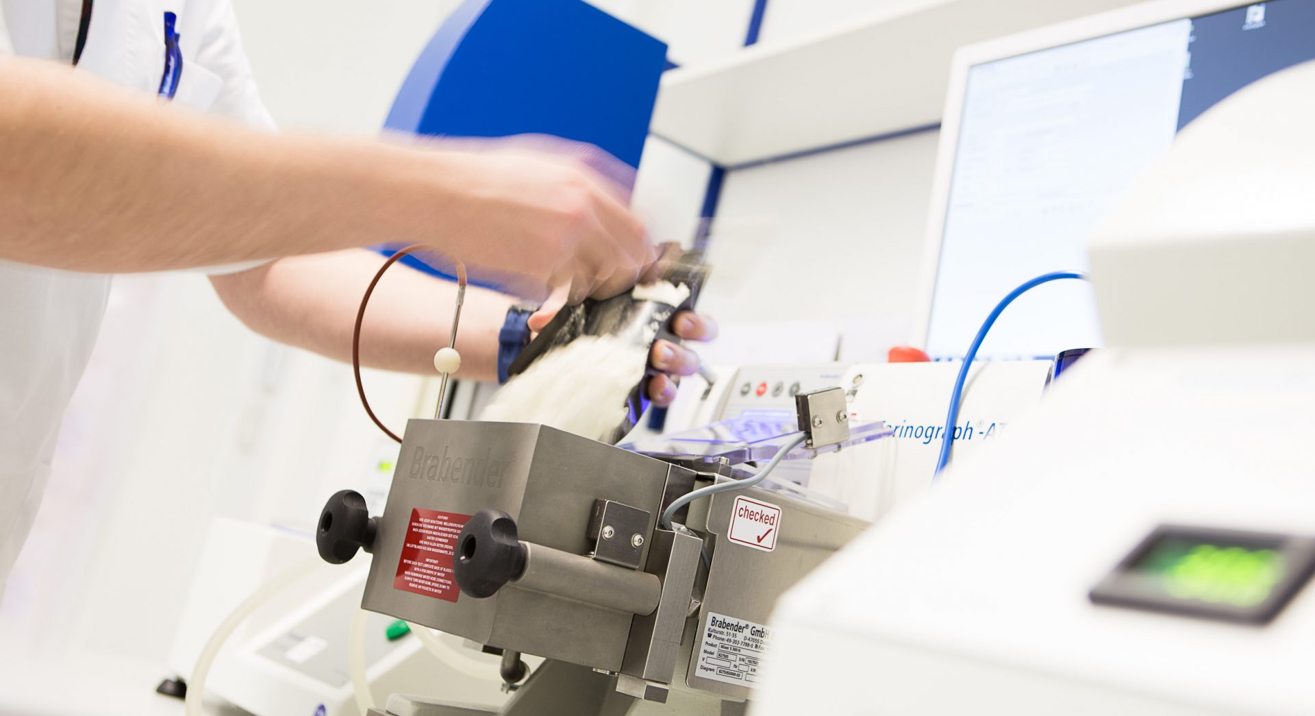 Hände prüfen den Teig in der Maschine