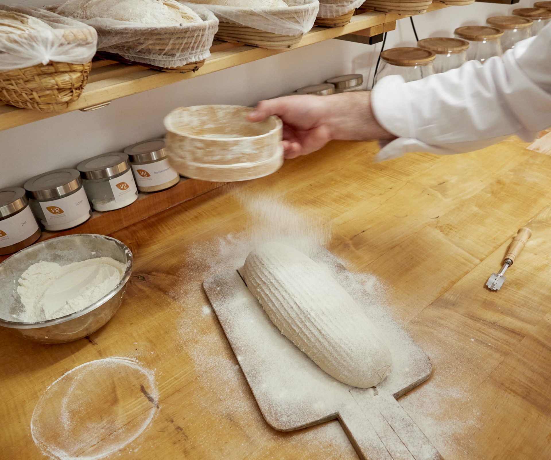 Brotlaib auf der Arbeitsfläche wird mit Mehl bestreut.