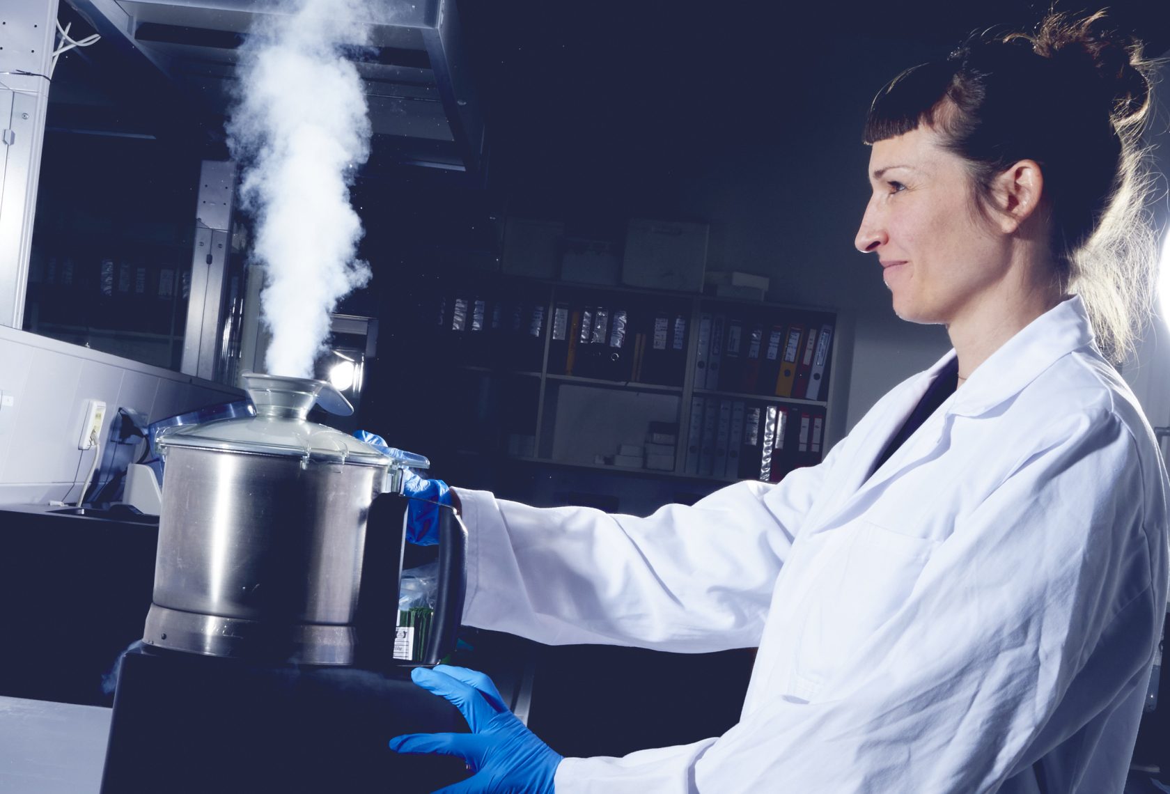 Forscherin im Labor vor einem dampfenden Gefäß