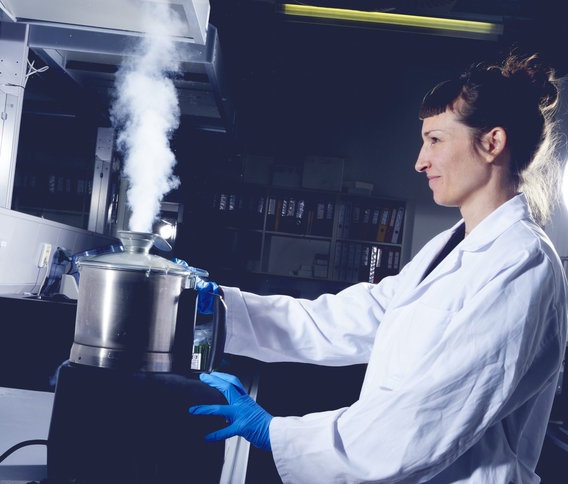 Forscherin im Labor vor einem dampfenden Gefäß