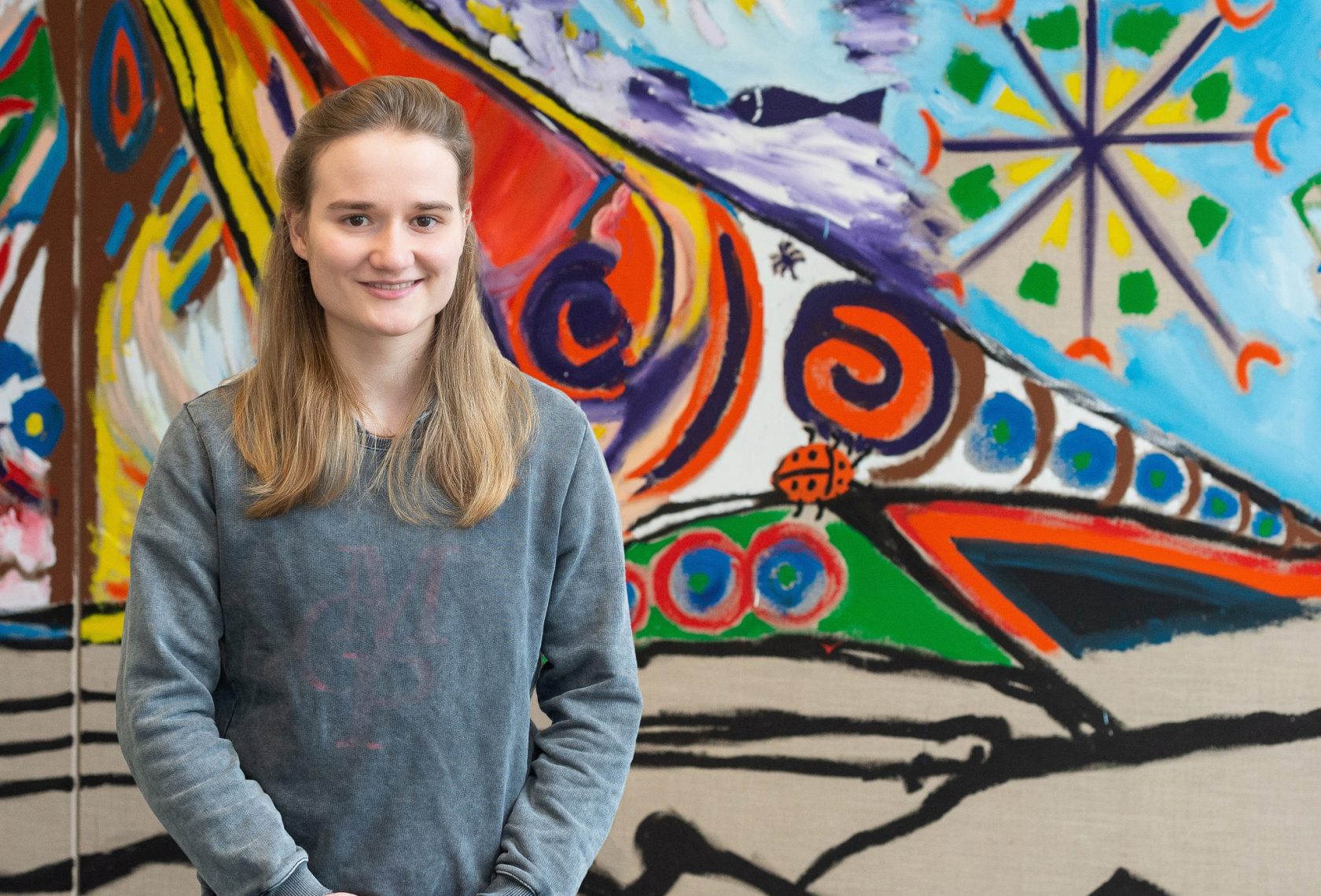 Portraitbild, Person vor einer bunten Wand