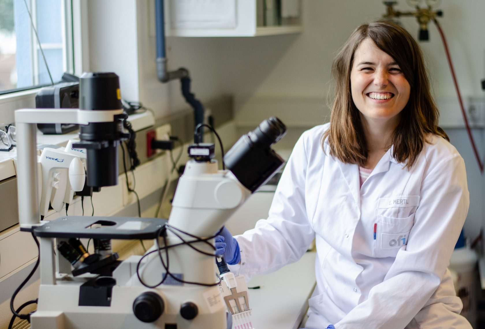 Forscherin vor einem Mikroskop