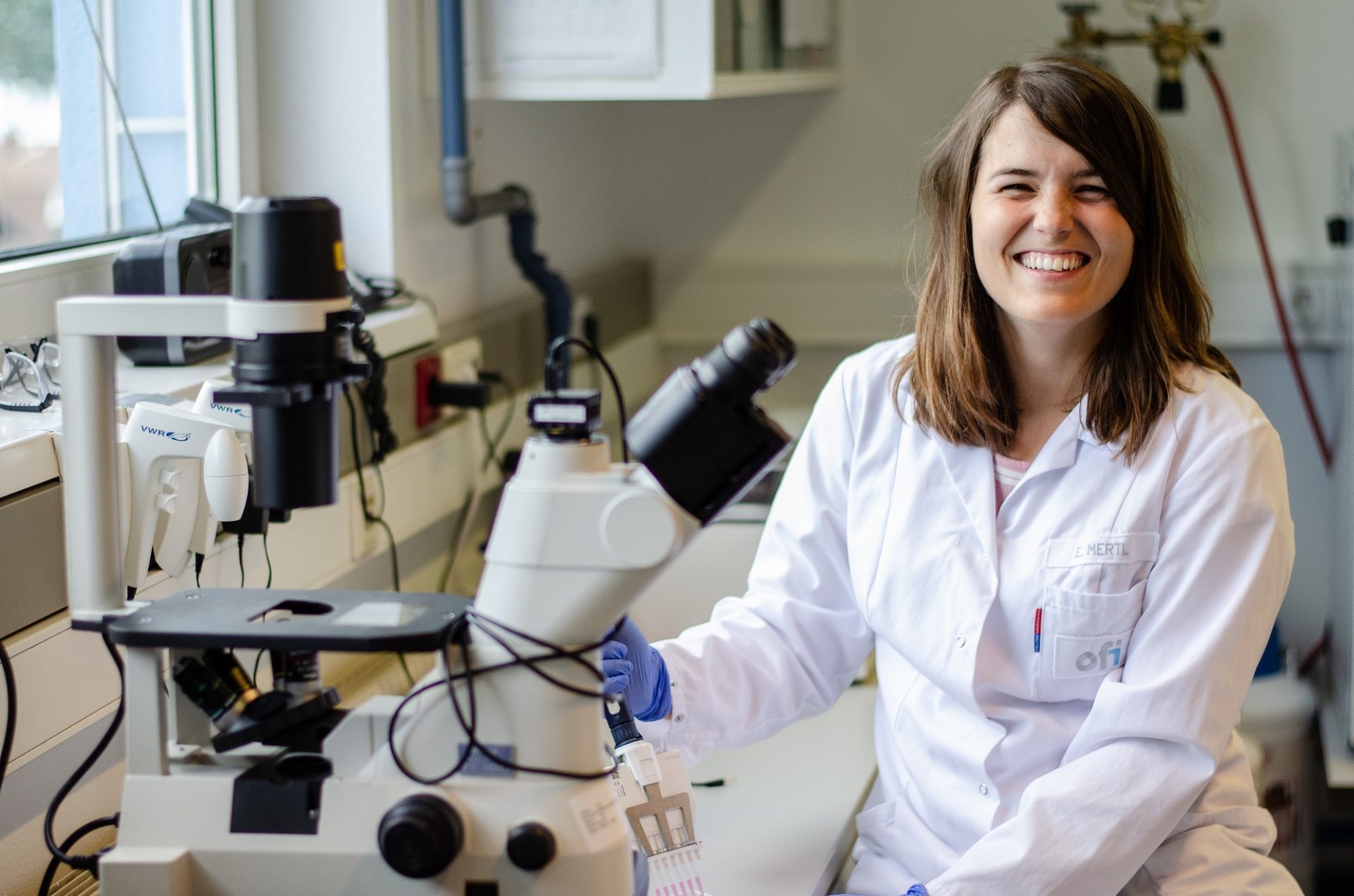 Forscherin vor einem Mikroskop