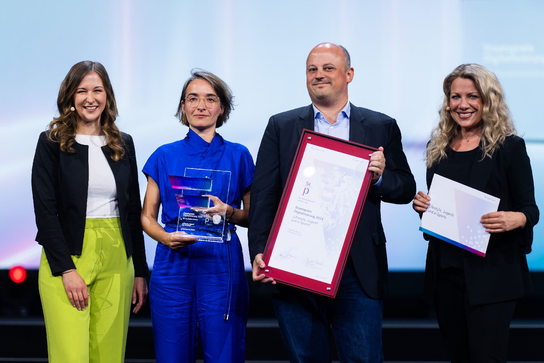 Vier Personen auf der Bühne bei einer Preisverleihung