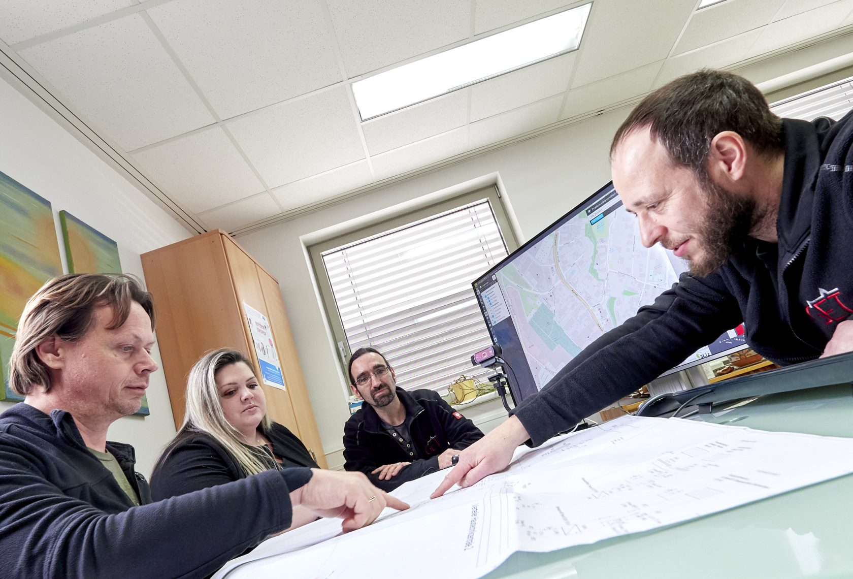 Vier Personen bei einer Besprechung im Büro