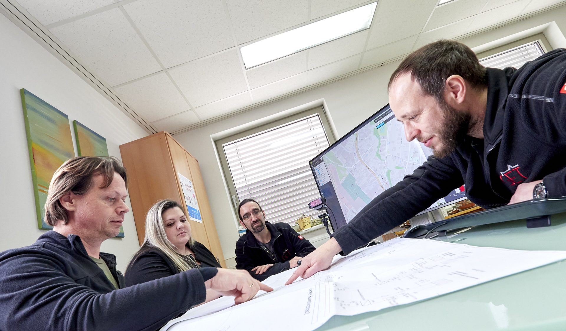 Vier Personen bei einer Besprechung im Büro