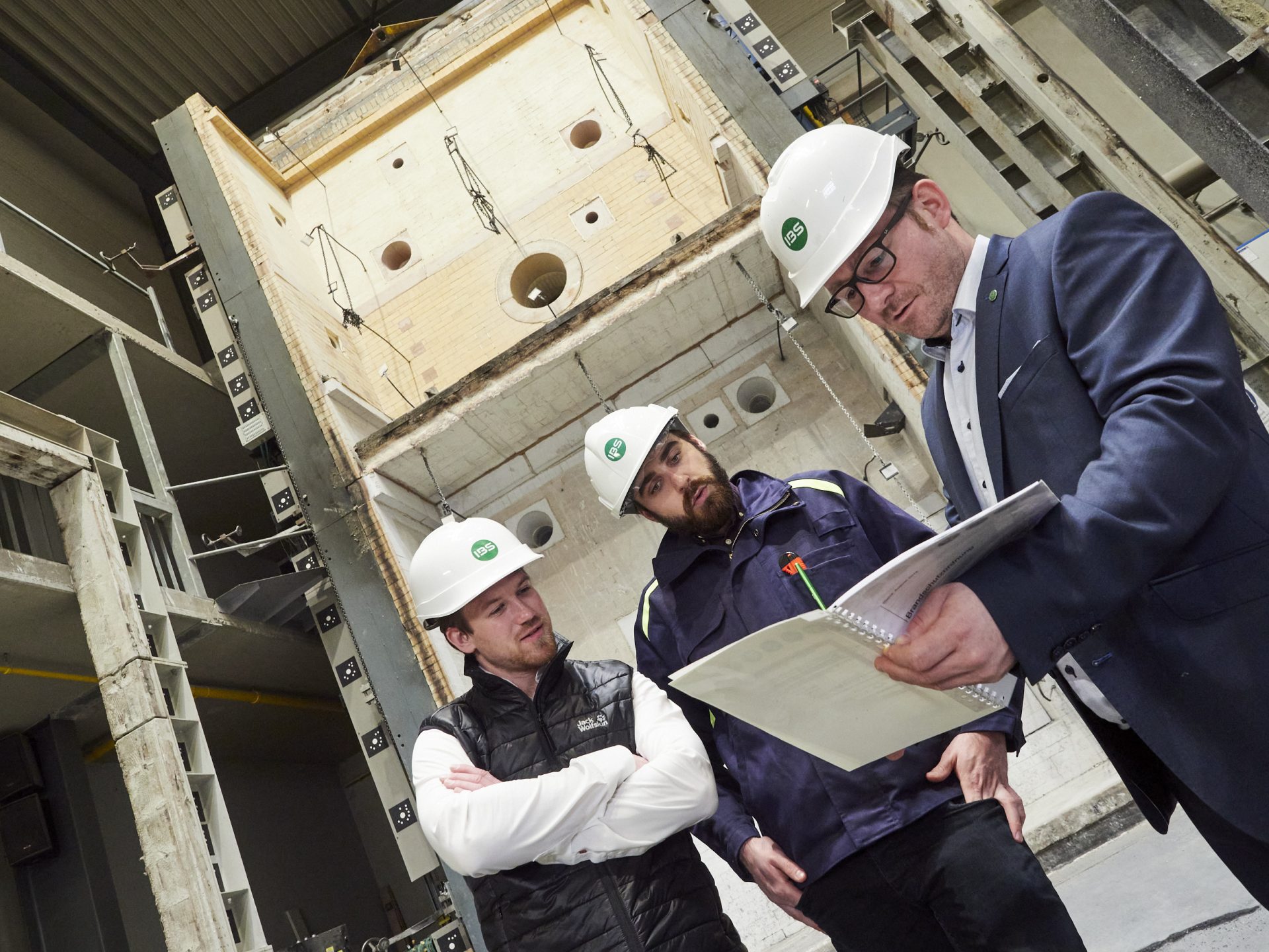 Menschen vor einem Plan in einer Prüfhalle