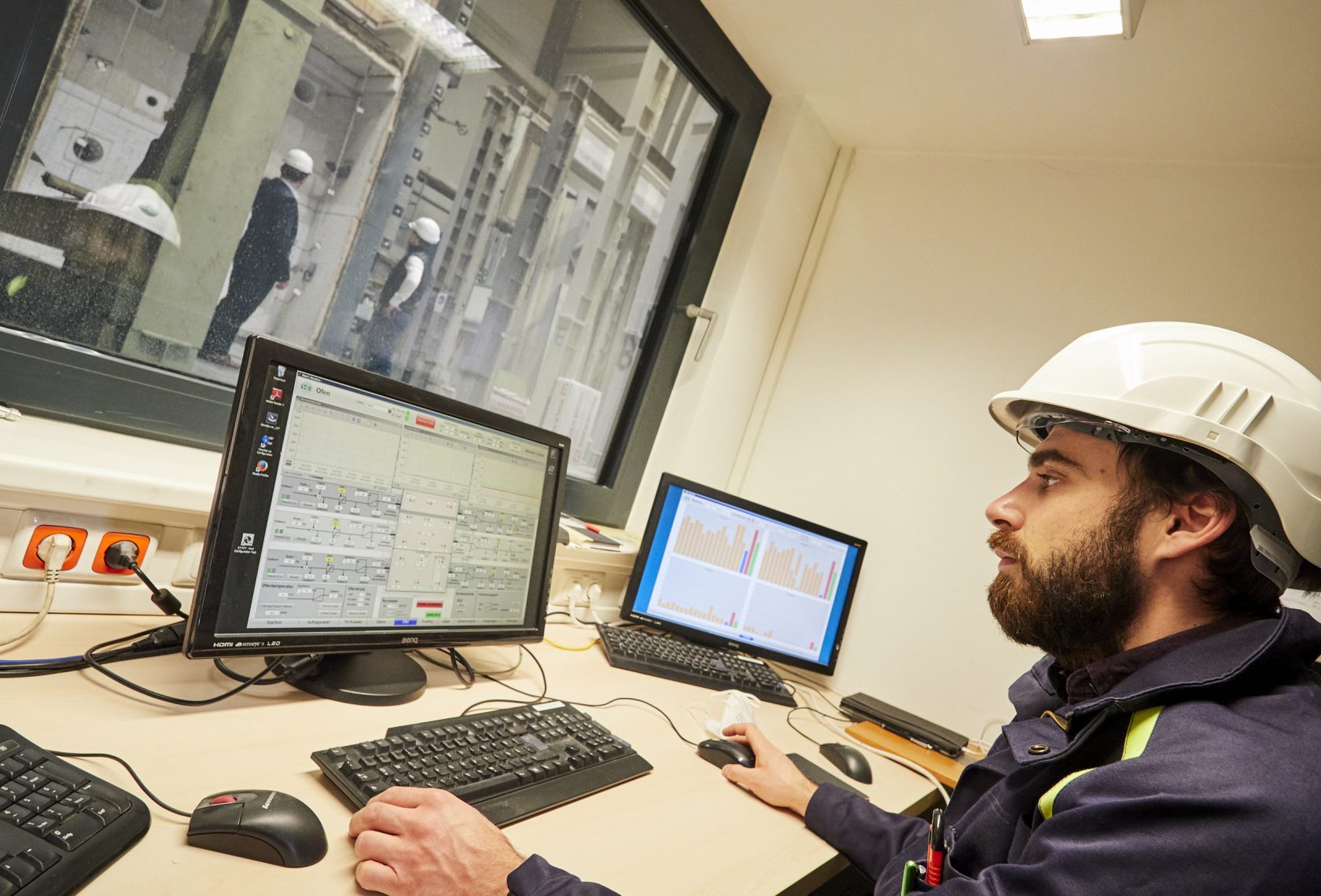 Mensch vor Bildschirmen in einer Prüfhallle