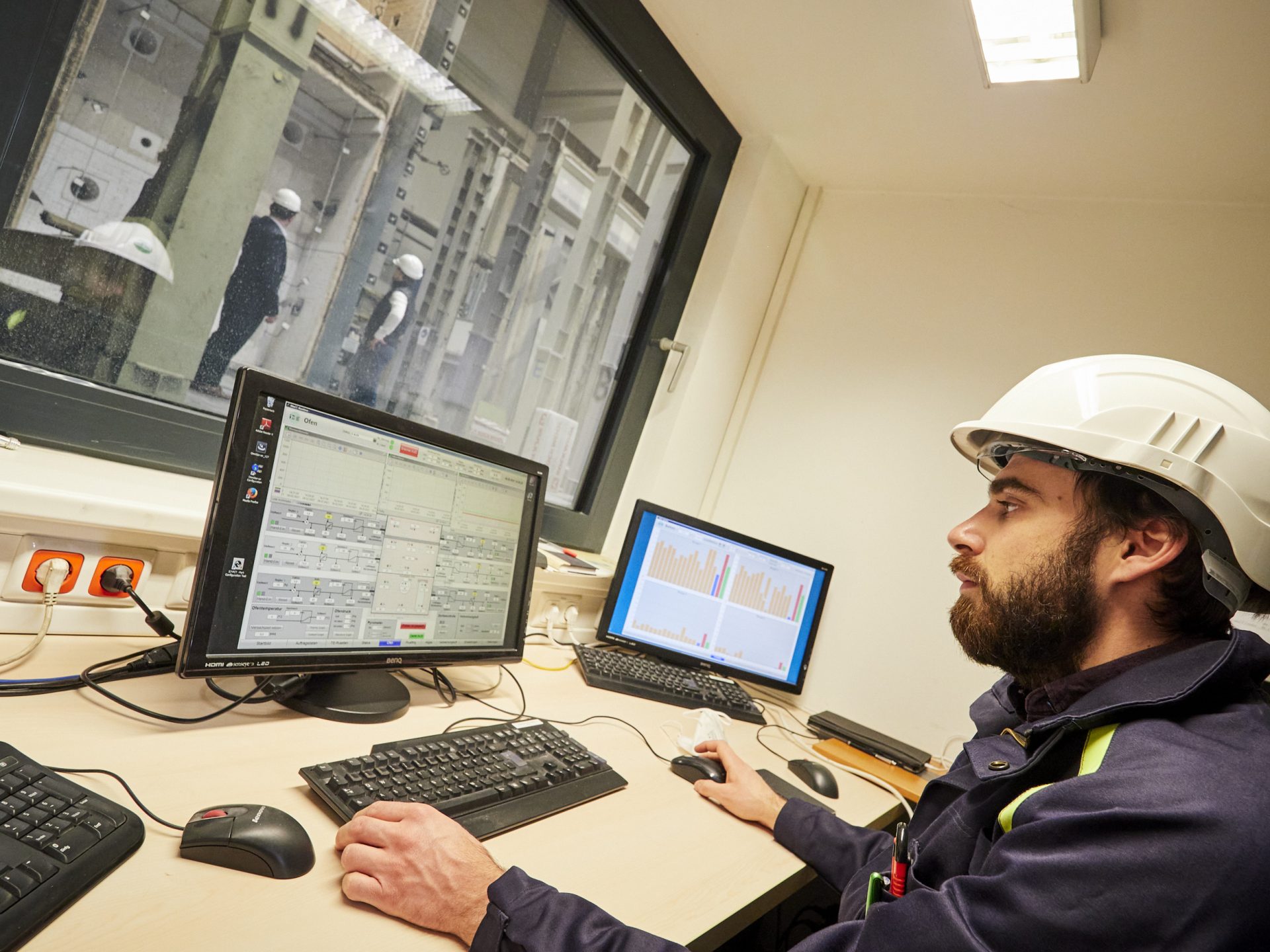 Mensch vor Bildschirmen in einer Prüfhallle