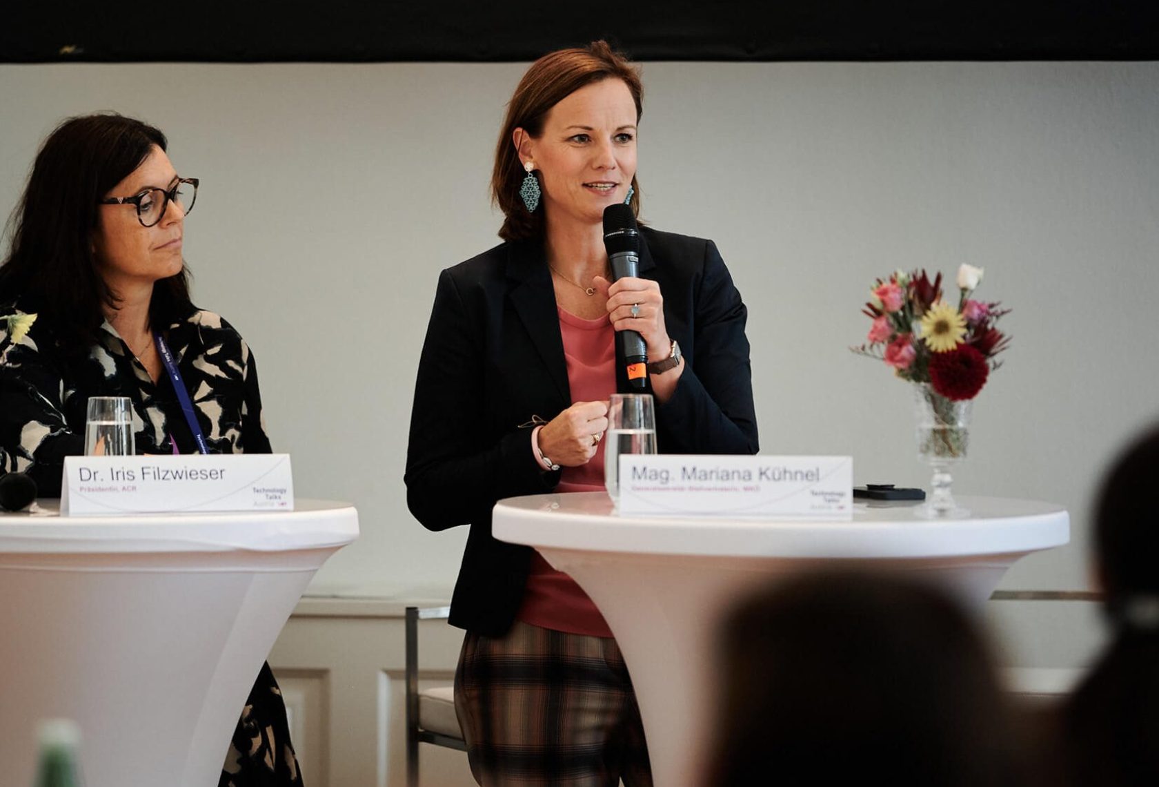 Zwei Vortragende hinter Stehtischen