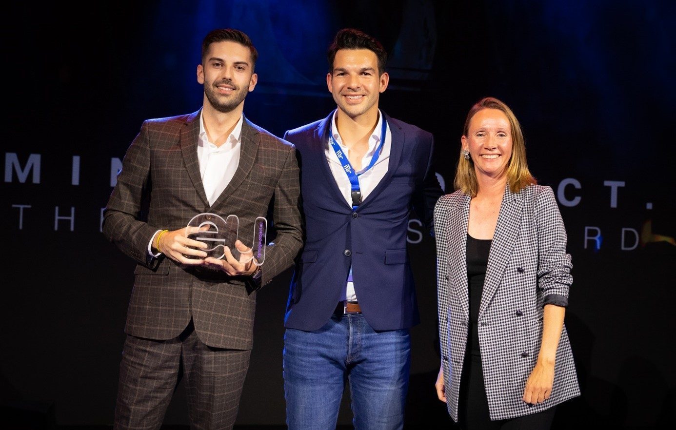 Drei Personen auf der Bühne bei einer Preisverleihung