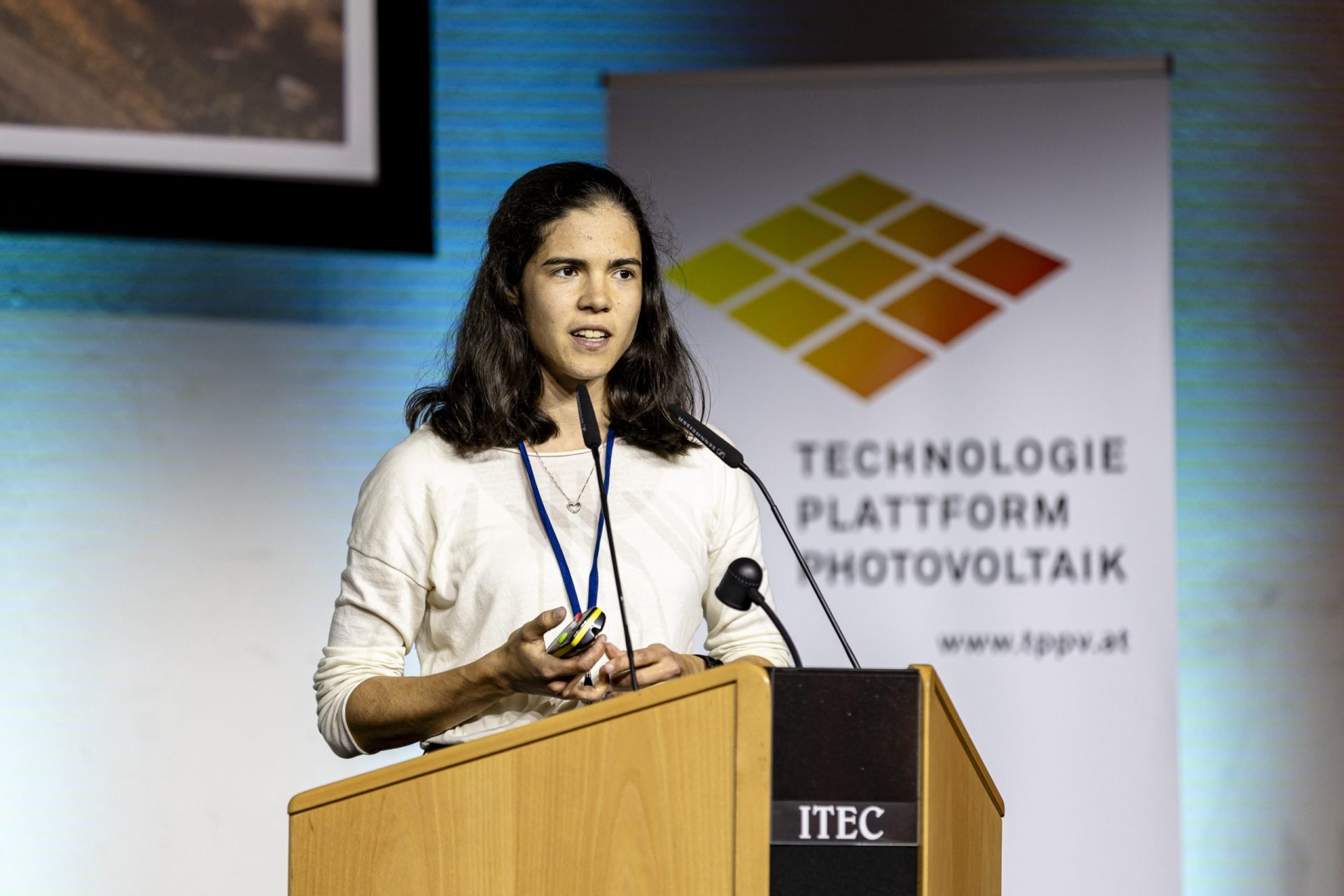 Frau vor Rednerpult bei einem Vortrag