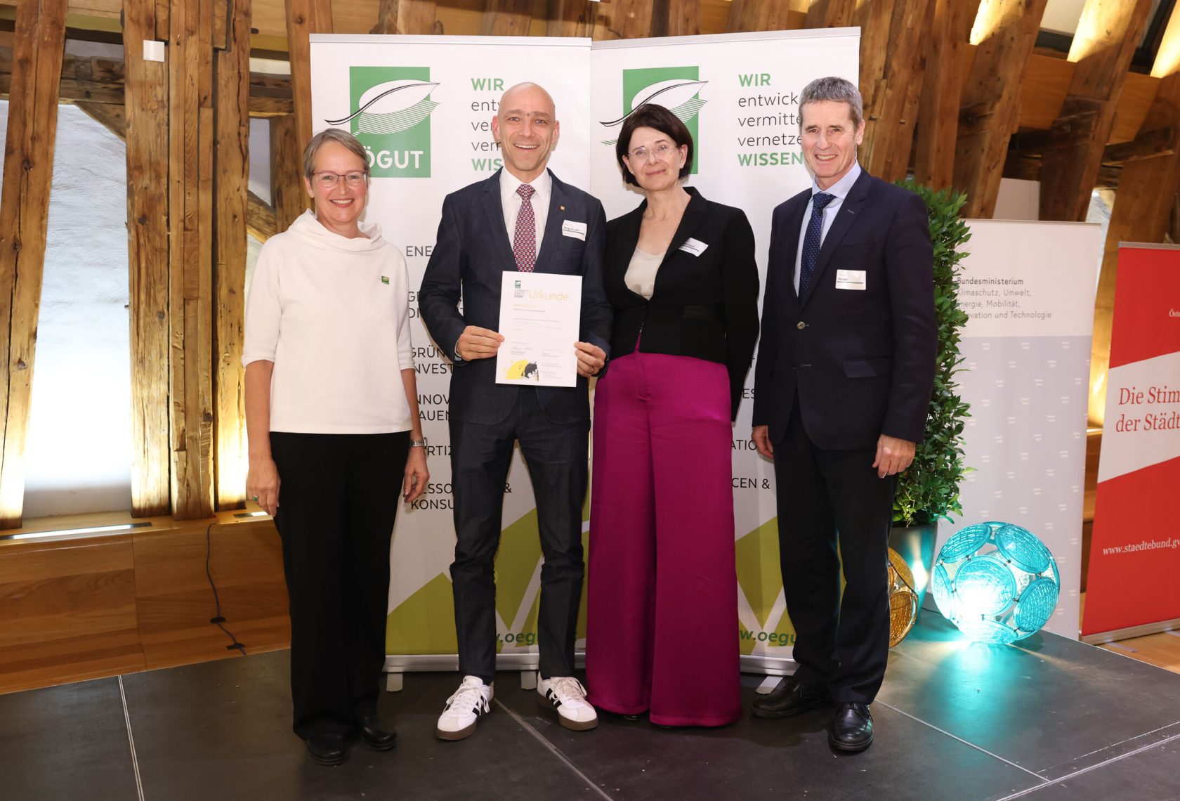 Vier Personen auf der Bühne bei einer Preisverleihung