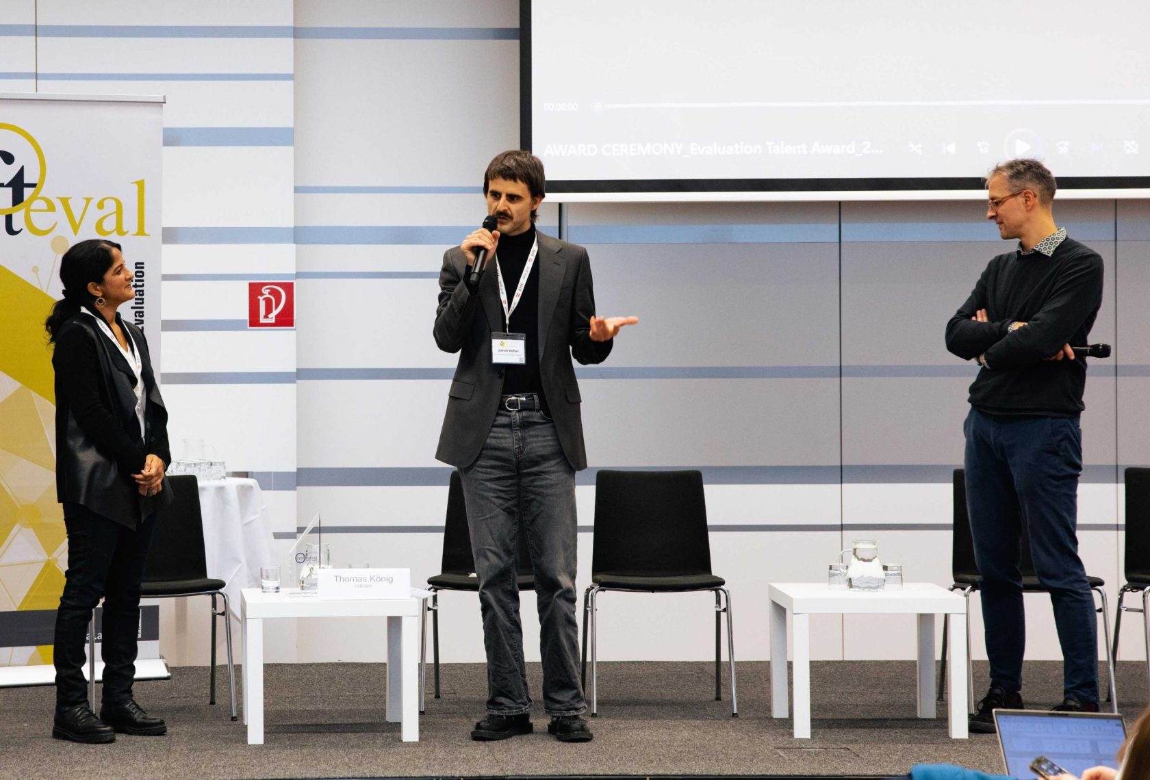 Drei Personen auf der Bühne im Rahmen einer Preisverleihung