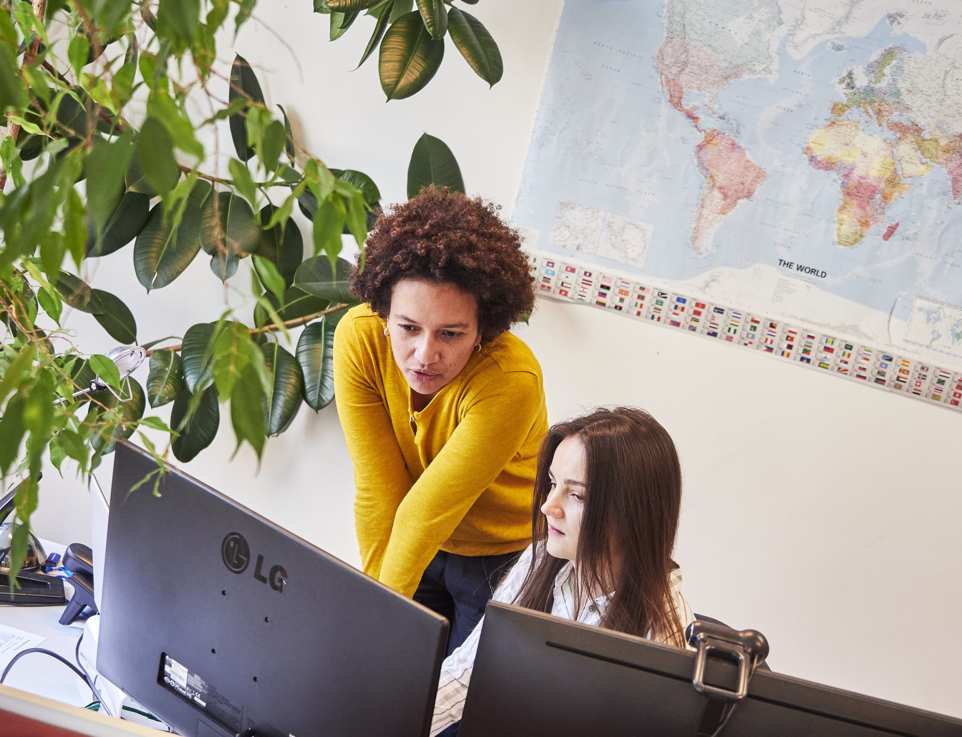 Zwei Frauen im Gespräch vor einem Computer-Bildschirm