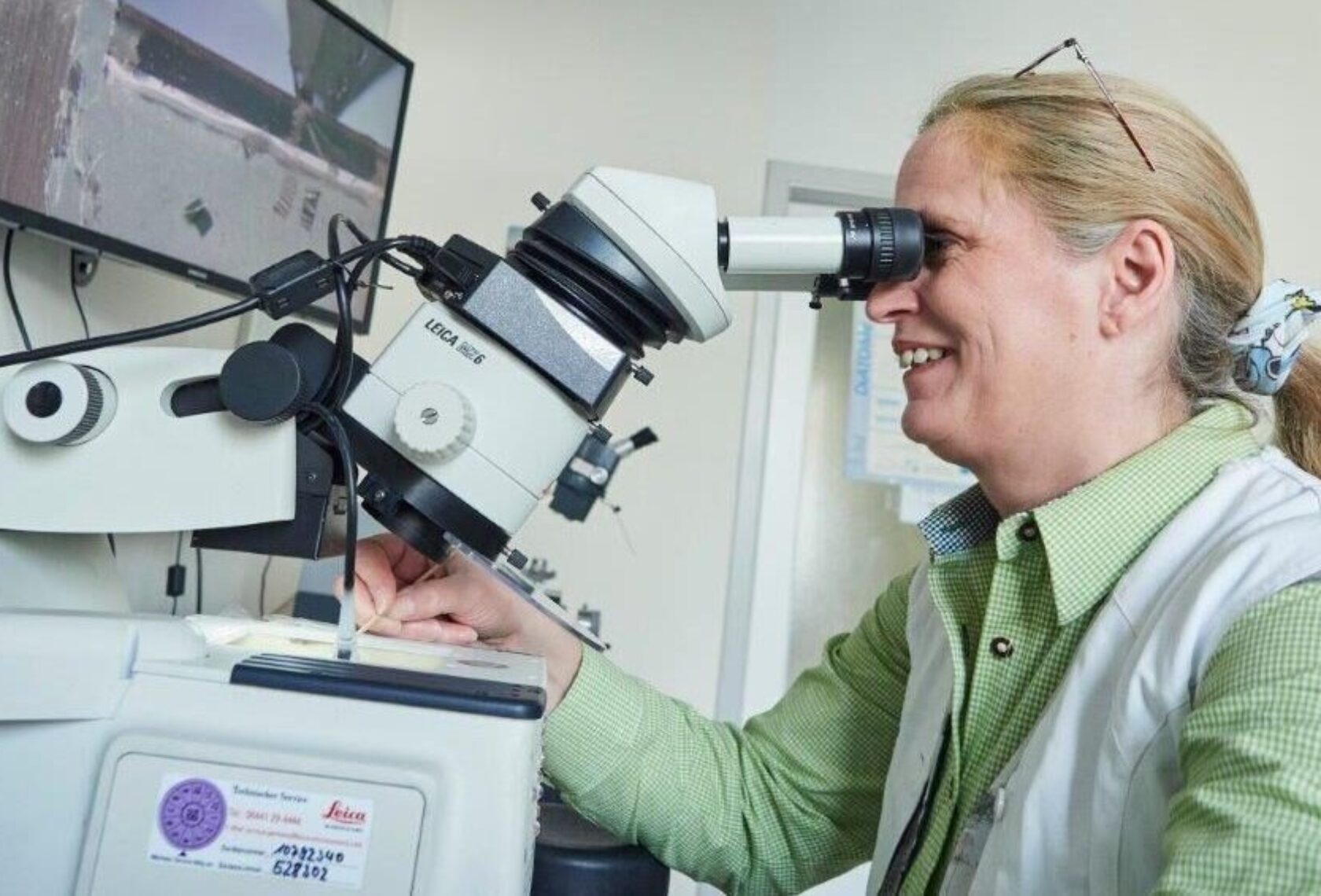 Forscherin an einem Mikroskop