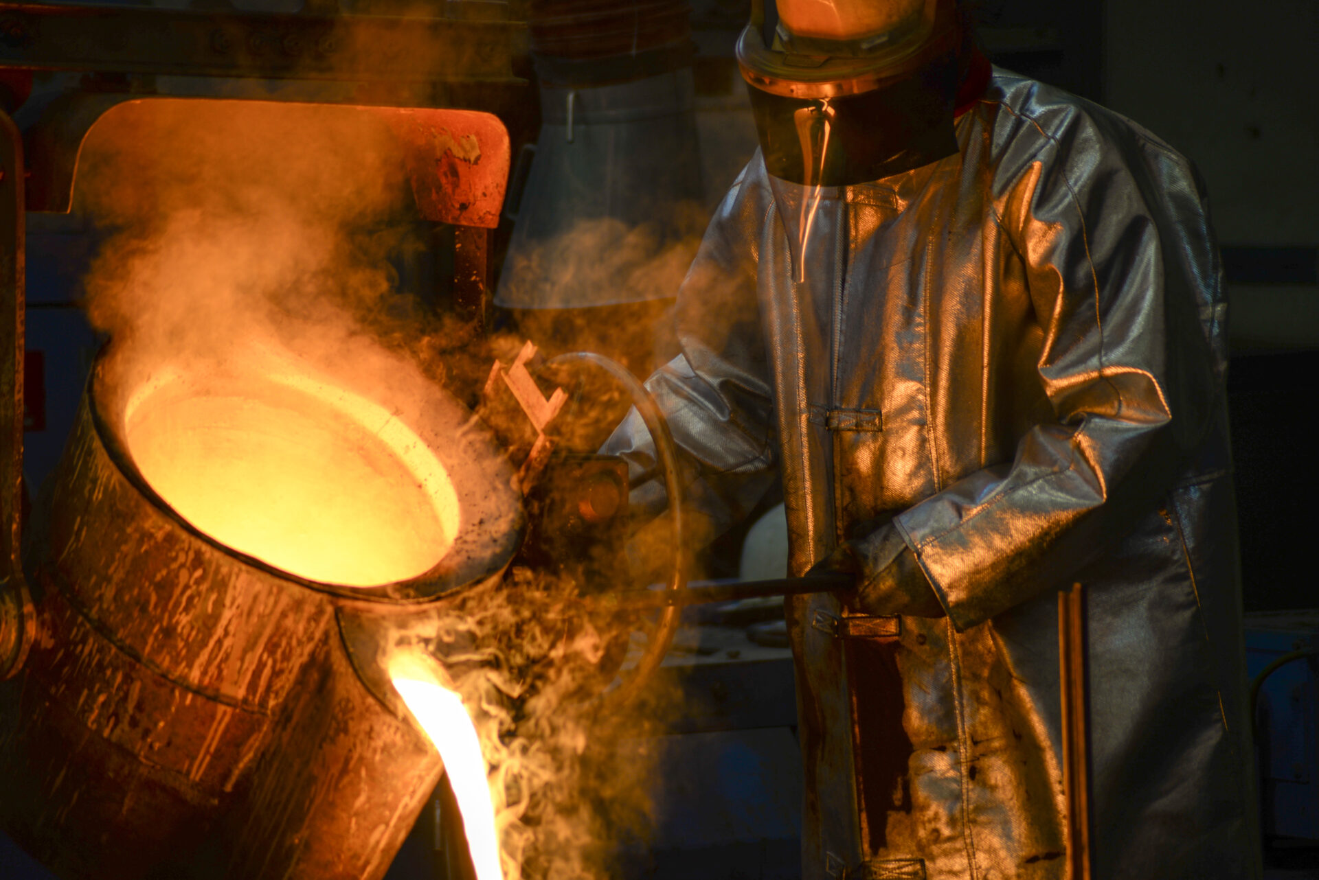 Grüner Guss Person mit Schutzanzug beim Gießen von Aluminium