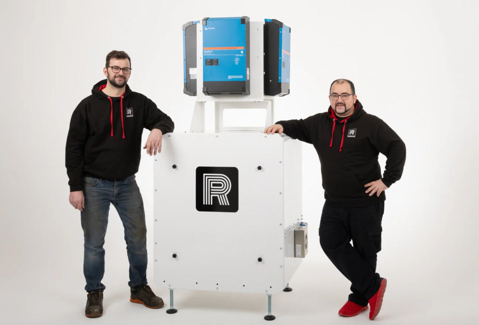 Zwei Männer mit einem Batteriespeicher in der Mitte