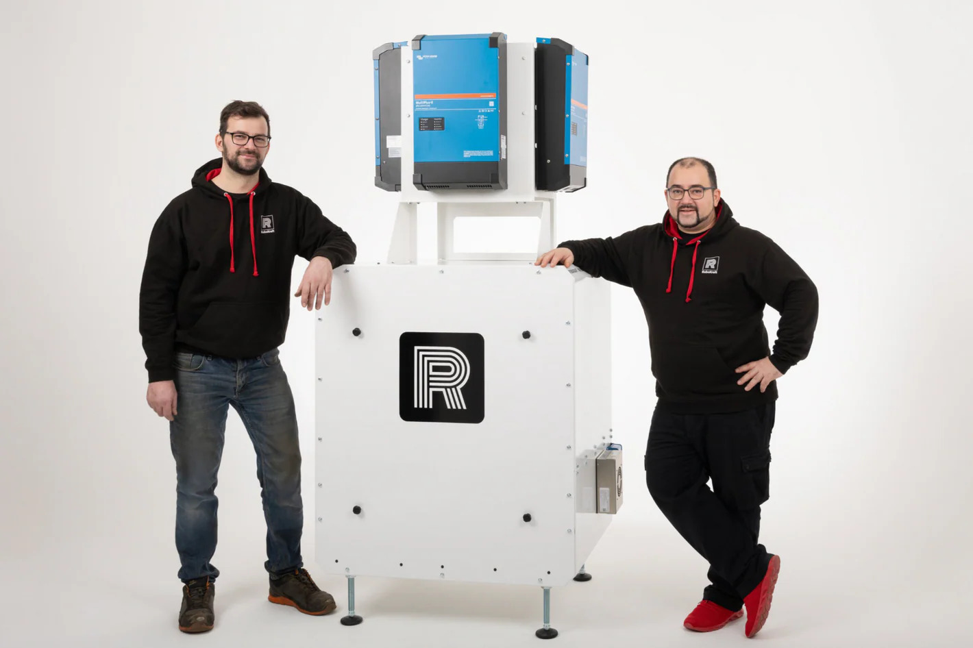 Zwei Männer mit einem Batteriespeicher in der Mitte