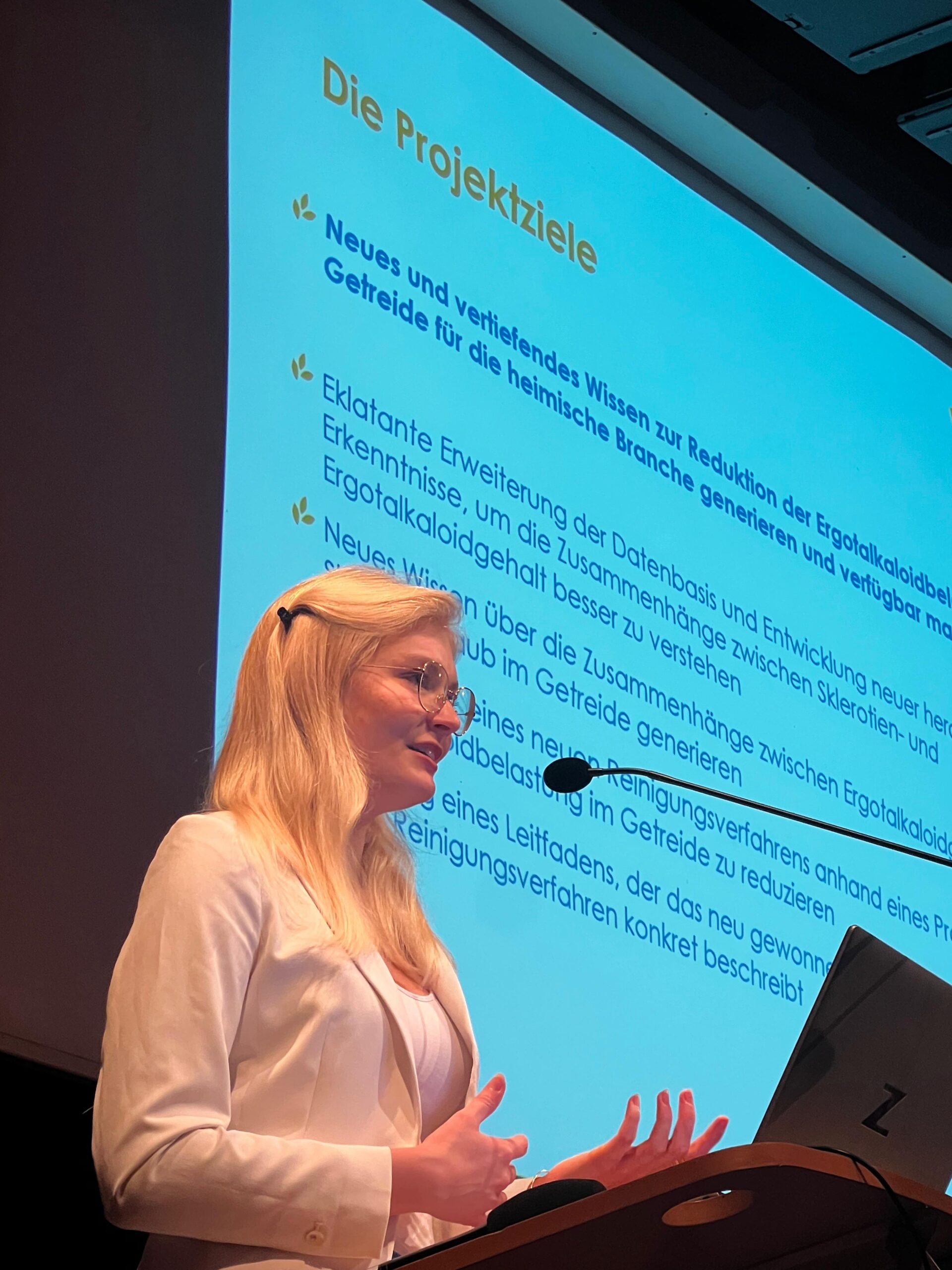 Frau bei einem Vortrag auf einem Podium