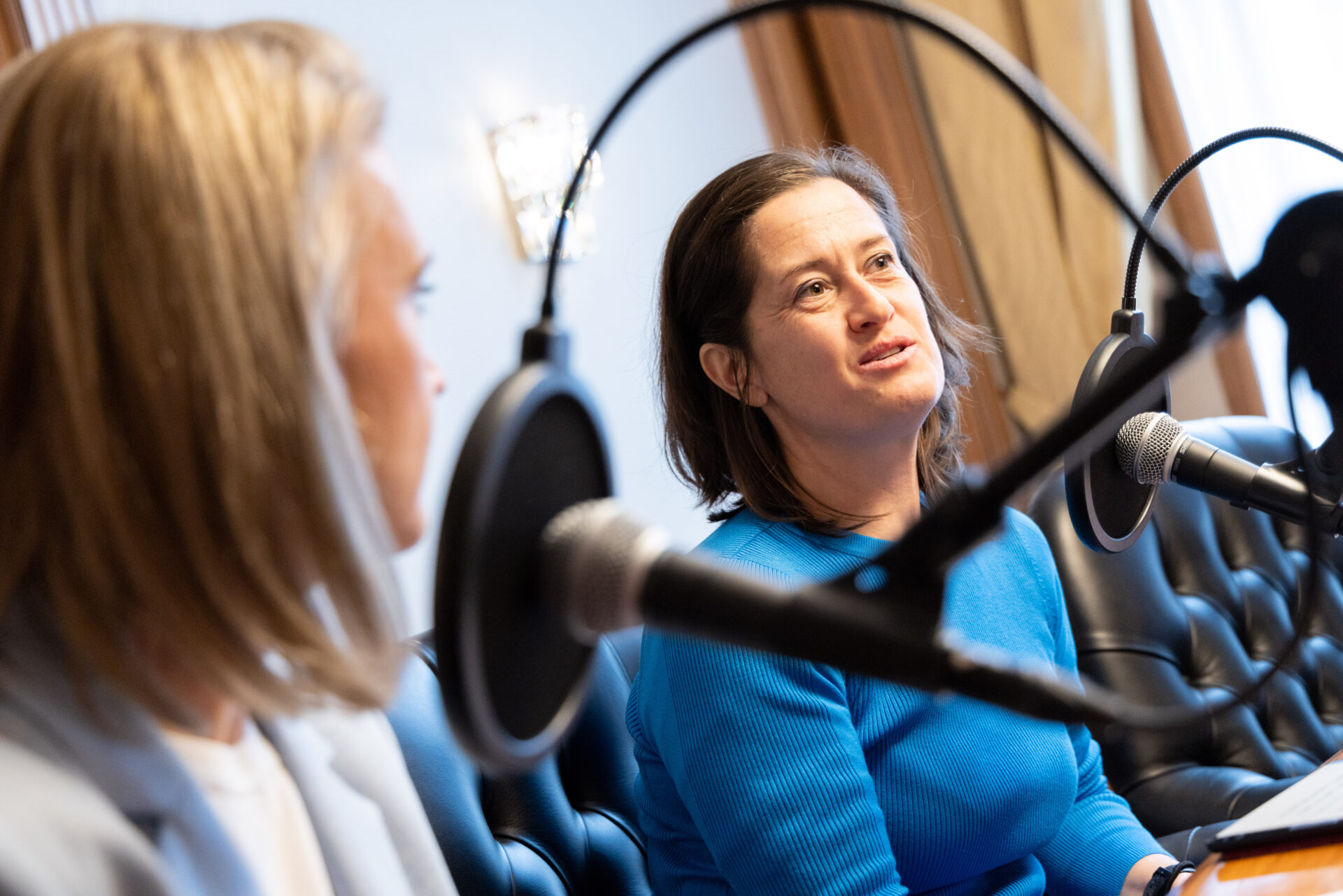 Zwei Frauen vor Mikrofonen bei einer Podcast-Aufnahme