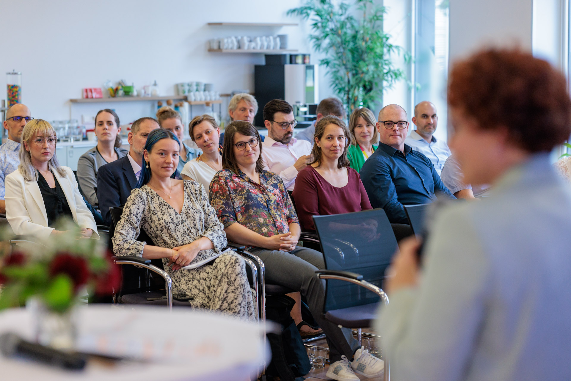 Blick ins Publikum bei einer Veranstaltung mit Sprecherin im Vordergrund