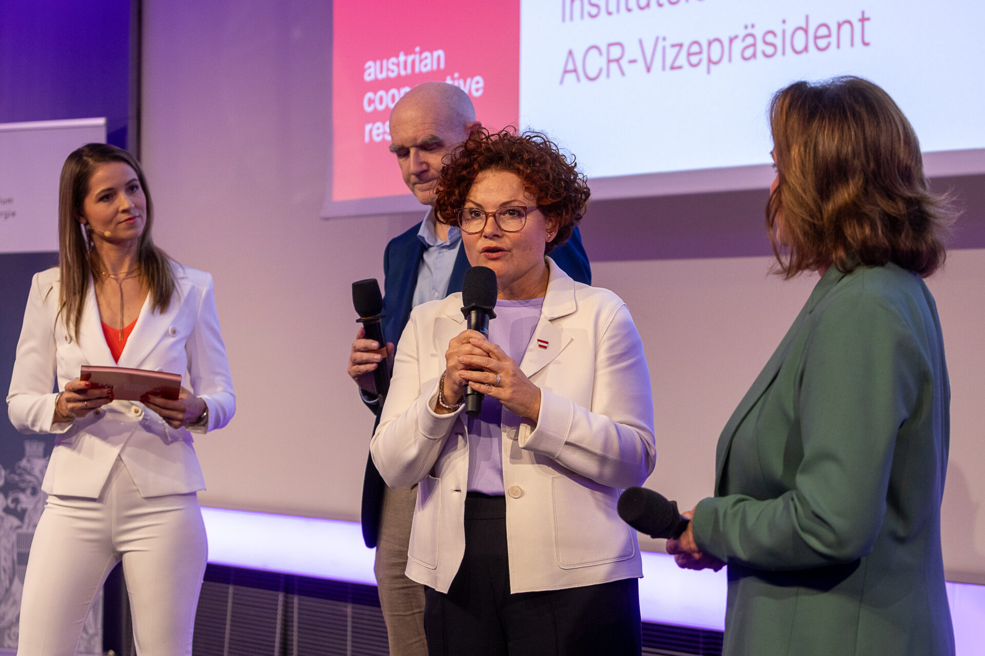 Frau mit Mikrofon im Rahmen einer Podiumsdiskussion